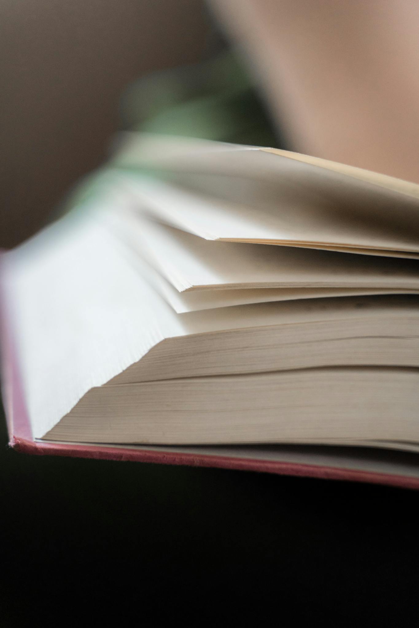 A close-up photograph of an open book, showing the details of turning pages.